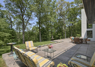 A backyard patio featuring two chairs and a couch