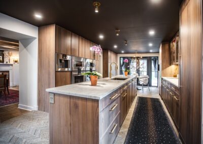 A spacious kitchen featuring a large island going down the center and elegant wooden cabinets