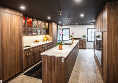 A spacious kitchen featuring a large island going down the center and elegant wooden cabinets
