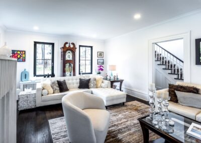A view of the living room looking from the fireplace to the sectional couch with the grandfather clock behind it.